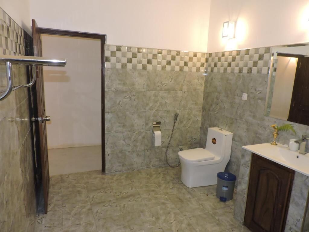 Casa de banho com sanita, lavatório e zona de duche.