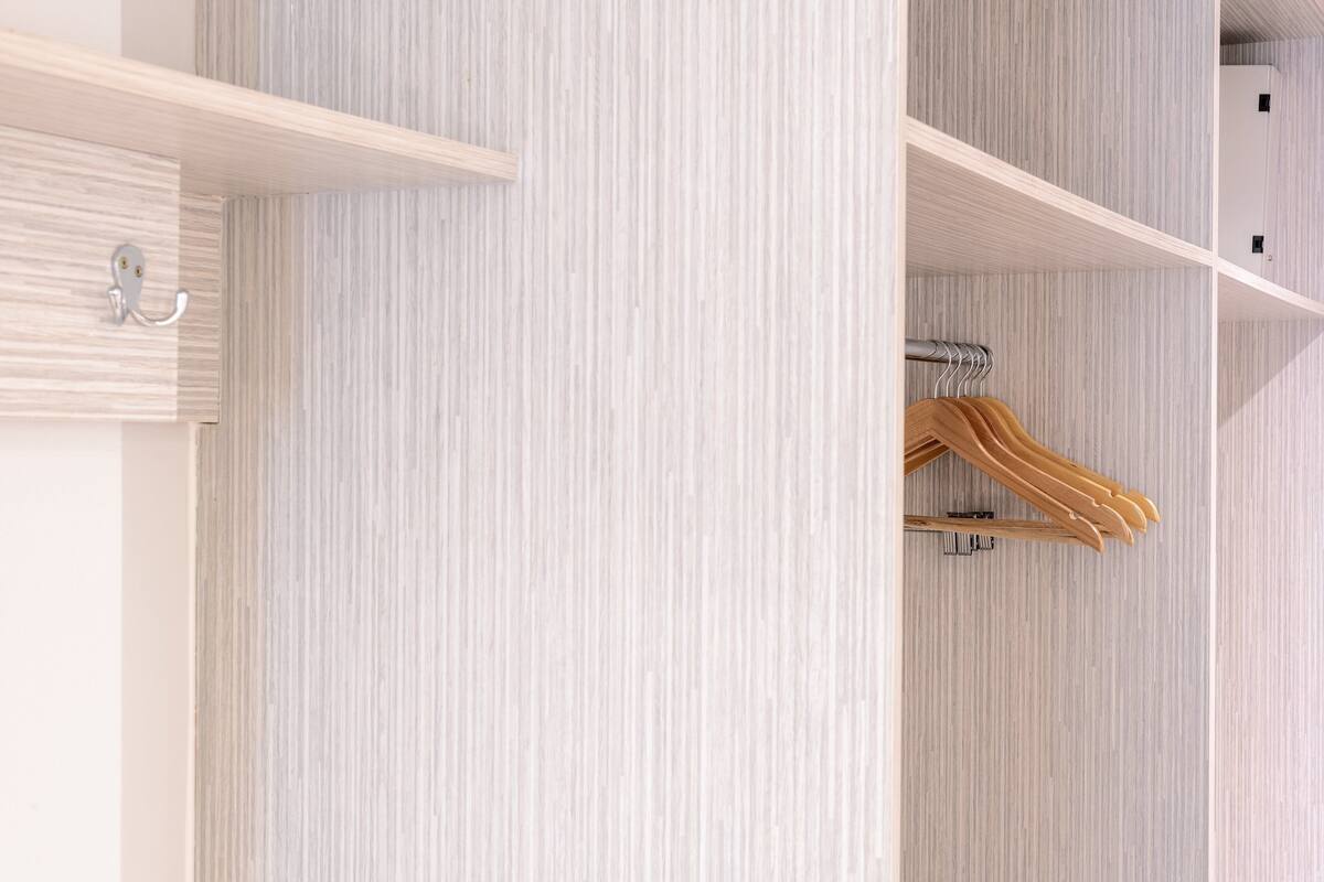 Ein Kleiderschrank mit Holzaufhänger und Metallhaken.