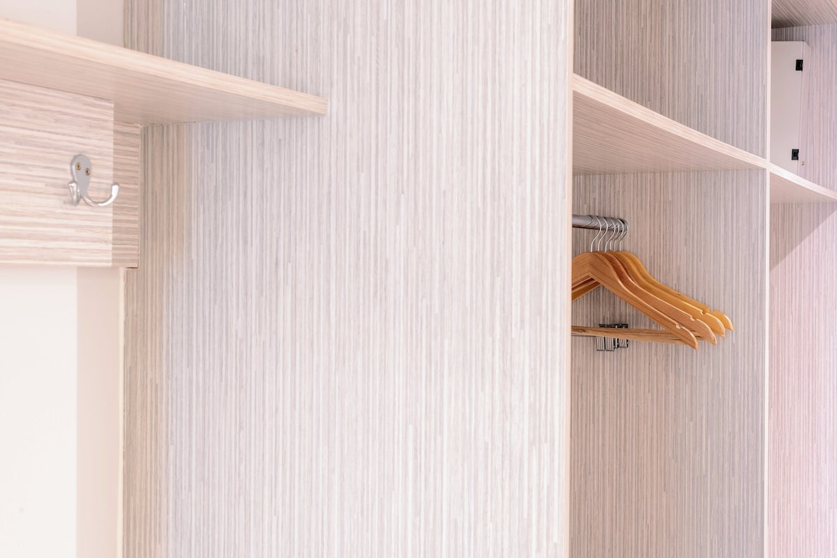 A wardrobe with wooden hangers and a metal hook.