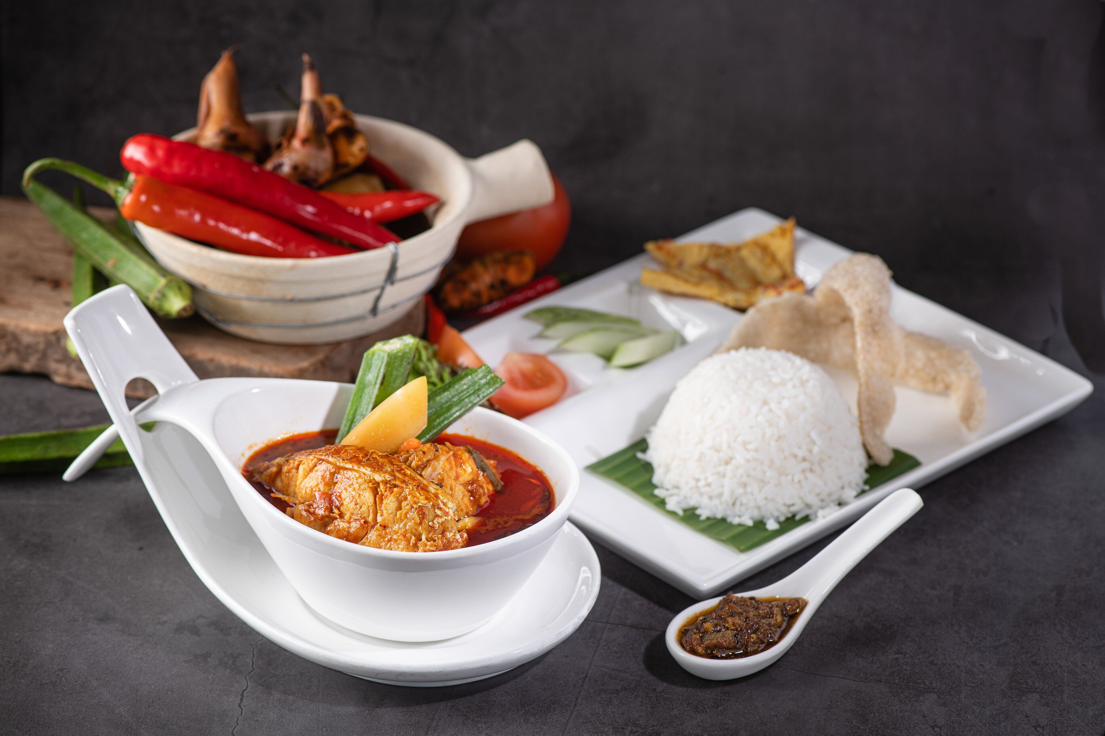 A meal with rice, fish, vegetables, and a bowl of sauce.