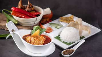 A meal with rice, fish, vegetables, and a bowl of sauce.