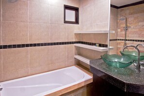 A modern bathroom with a bathtub, a green glass sink, and a shower. - Victorian Samui Condominium (Koh Samui)