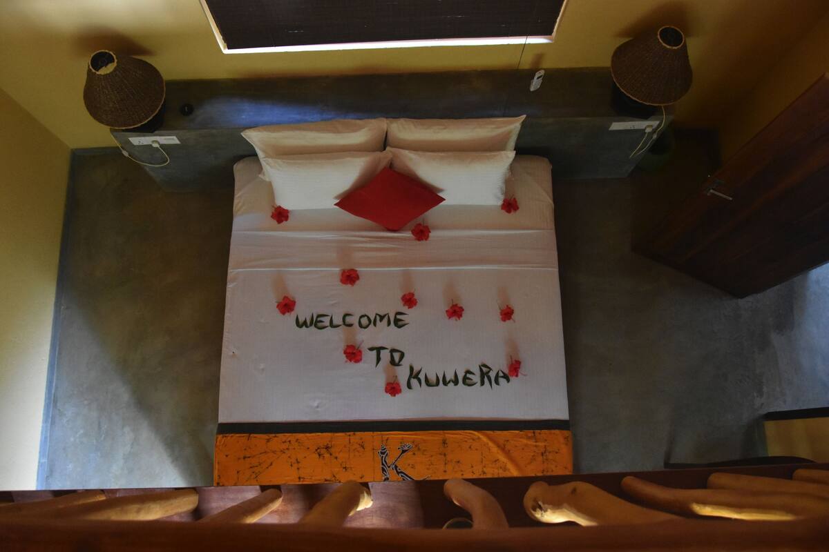 A bed with a message board that reads "WELCOME TO KWERARA".