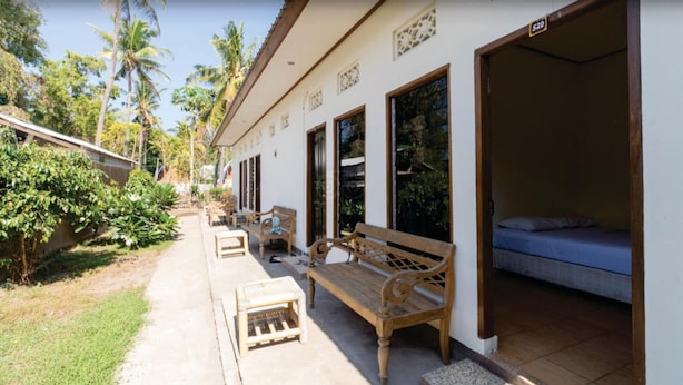 Una cabaña con patio, muebles de madera y una cama.