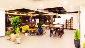 A modern interior with a seating area, dining space, and a bookshelf. - Casa Mini Hotel (Gyeongju)