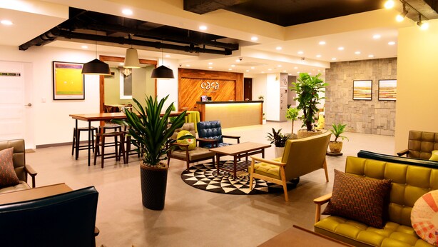 A modern lobby with a reception desk, seating area, and potted plants. - Casa Mini Hotel (Gyeongju)