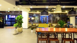A modern interior with a wooden dining table, multiple chairs, and potted plants. - Casa Mini Hotel (Gyeongju)