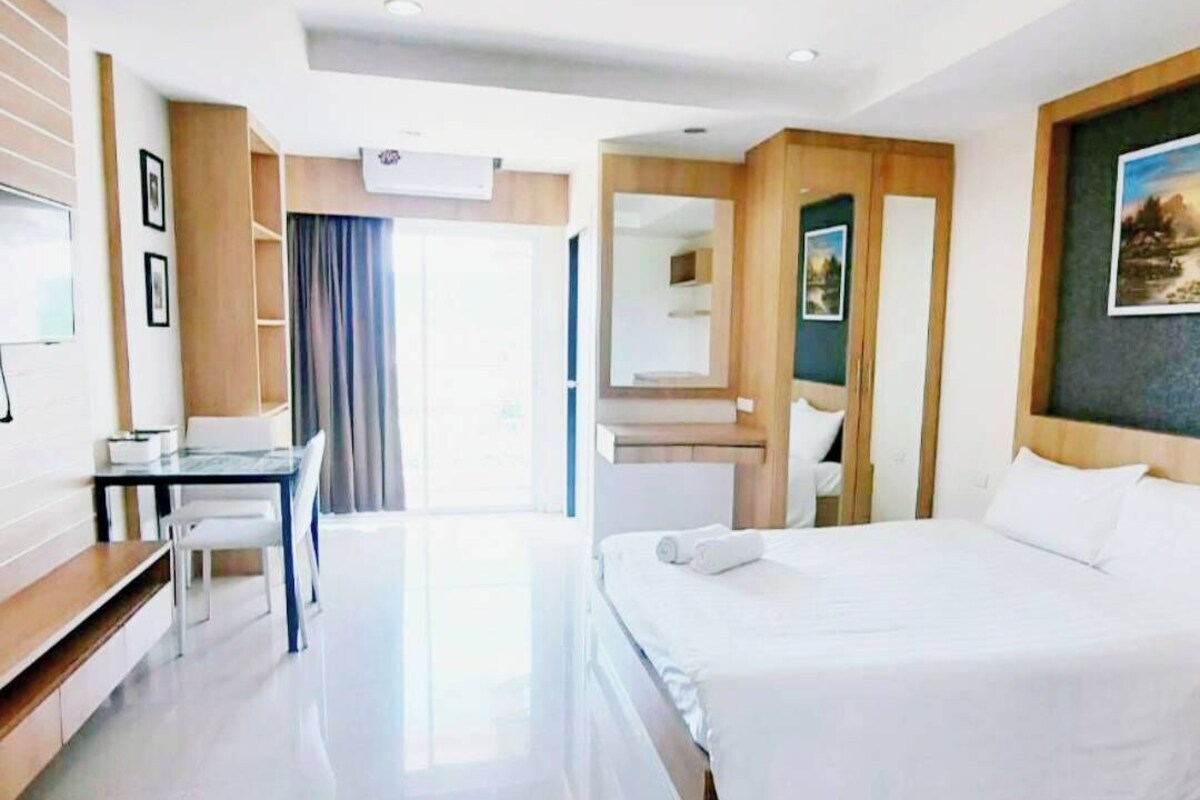 Une chambre d’hôtel moderne avec un grand lit, un bureau et une chaise.