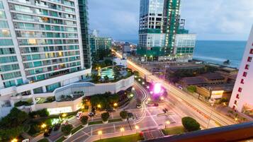 A high-rise hotel with multiple floors, a rooftop garden, and a view of the ocean.