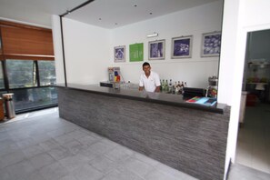 A modern hotel reception area with a counter, framed artwork on the wall, and a window with a view. - Colombo Residencies (Colombo)