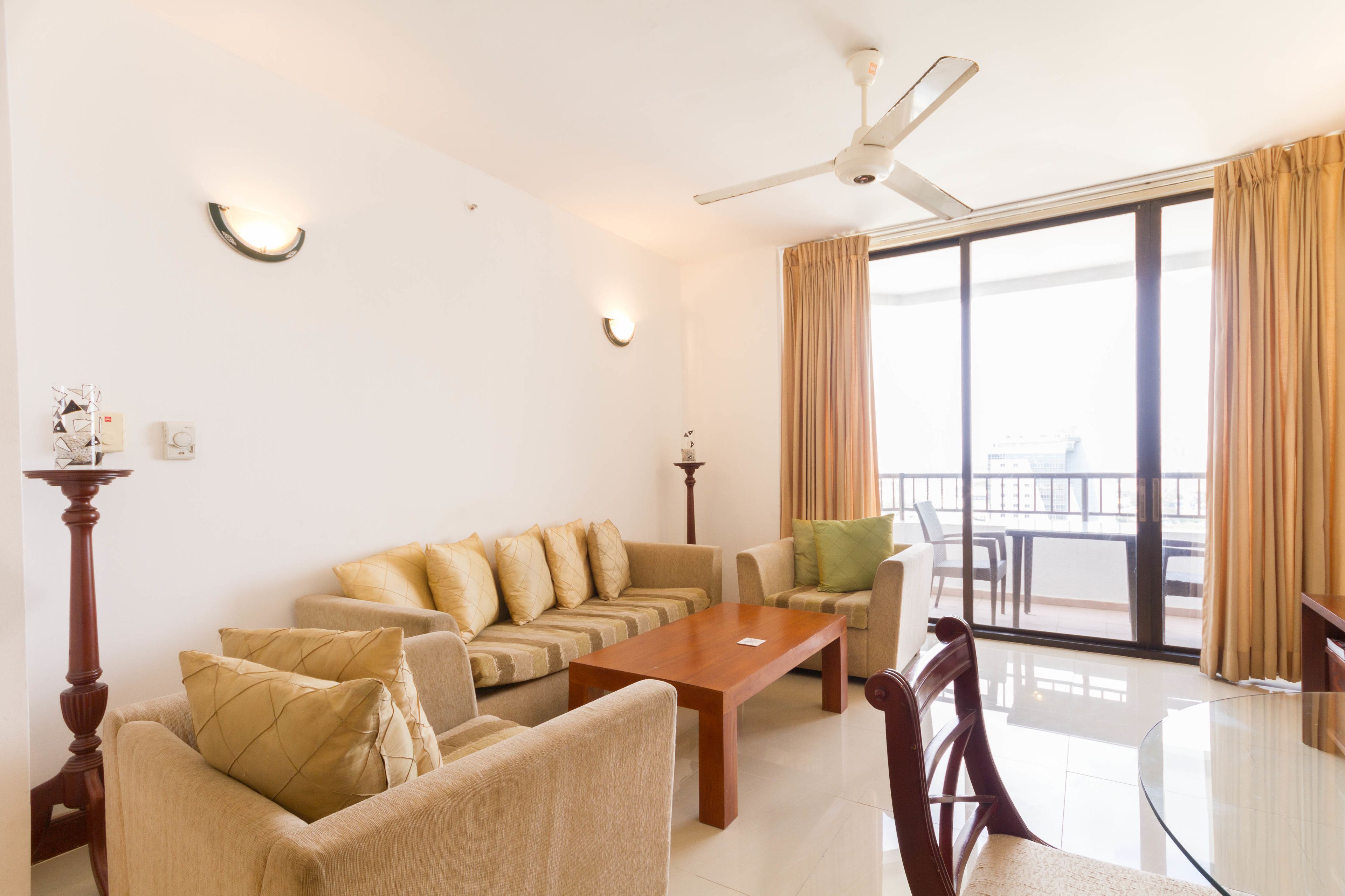 A spacious living room with a sofa set, a wooden coffee table, and a dining table with chairs.