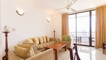 A spacious living room with a sofa set, a wooden coffee table, and a dining table with chairs.
