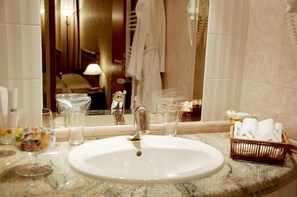 A bathroom with a white sink, a mirror, and a towel rack. - Hotel Mirage (Burgas)