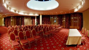 A conference room with a high ceiling, a central table, and rows of chairs. - Hotel Mirage (Burgas)