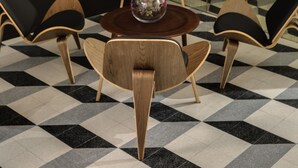 A modern interior with a checkered floor, black and wooden chairs, a round wooden table, and a spherical light fixture. - Navona Theatre Hotel (Rome)