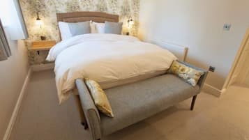 A bedroom with a bed, bedside tables, and a bench.