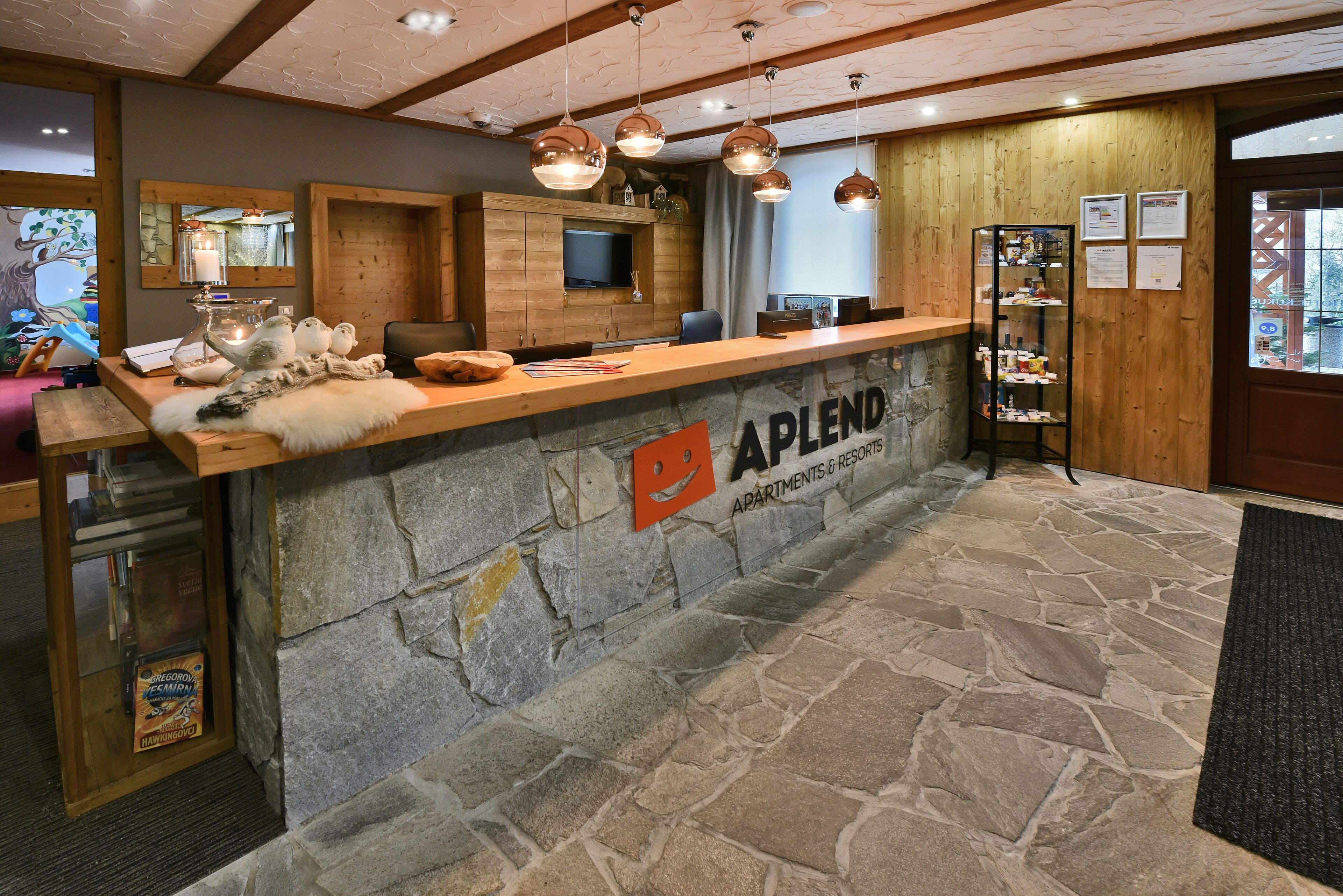 A reception area with a stone counter, wooden paneling, and pendant lighting.