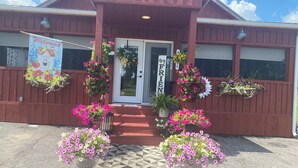 A building with a red exterior, a white door, and a 'Welcome' sign. - Northern Family Motel (Potsdam)