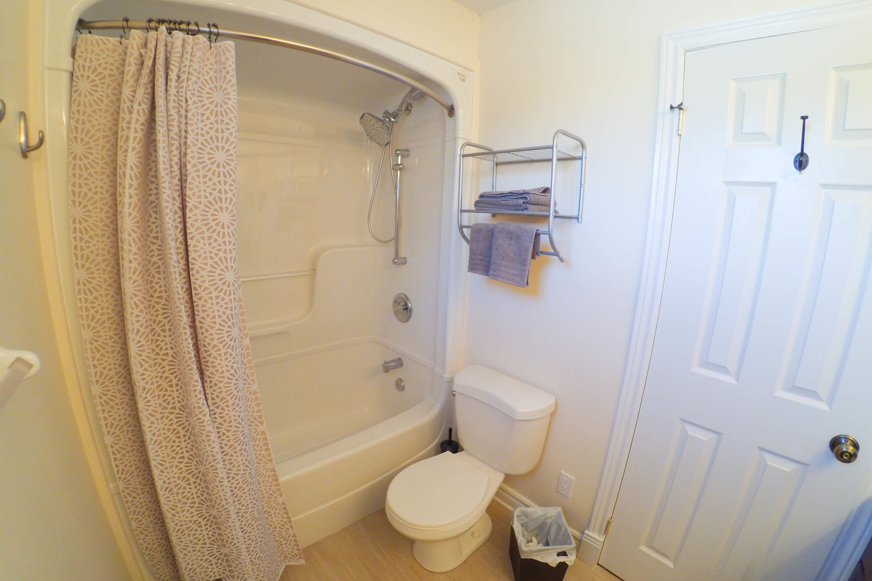 A bathroom with a bathtub, toilet, and a shower curtain.