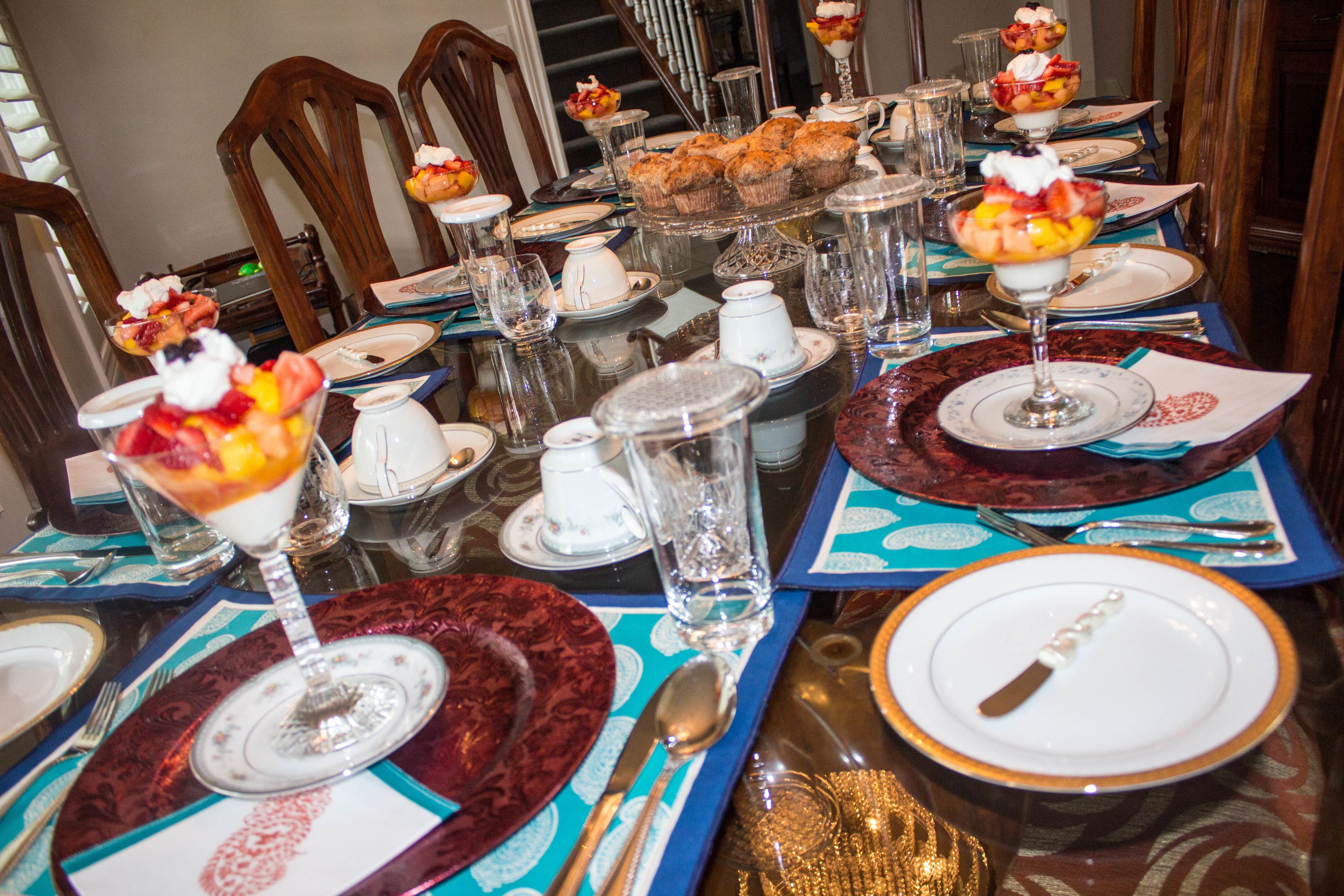 A formal dining table set with multiple plates, glasses, and cutlery.