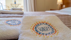 A hotel room with a bed, a nightstand, and a window with curtains. - Sunset Hotel (North Kynouria)