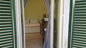 A room with a bed, a small table, and a chair.