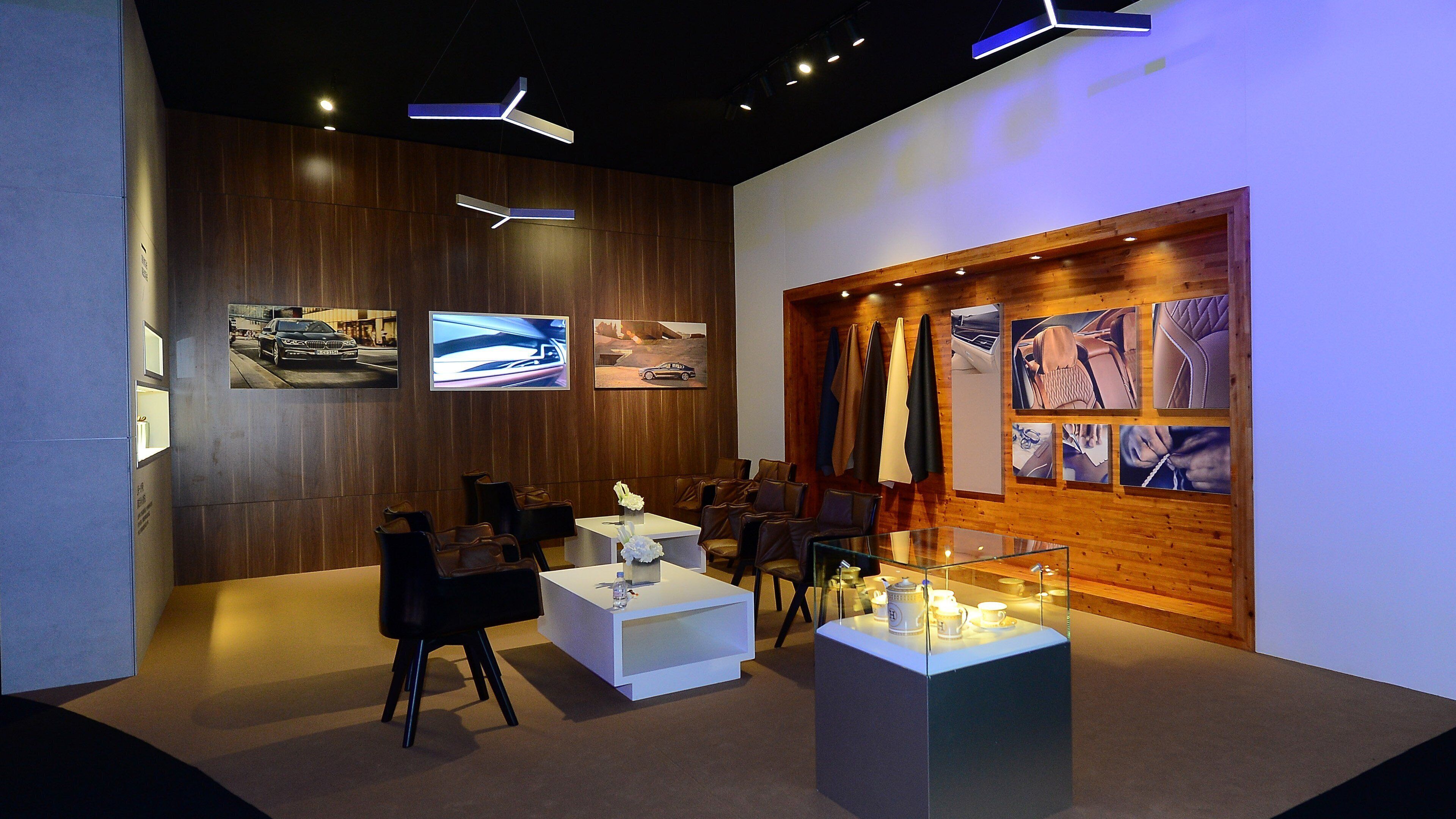 A modern interior with a seating area, wooden panel walls, and various framed pictures.