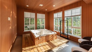 A modern bathroom with a wooden interior, a large bathtub, and large windows with blinds. - InterContinental Nantong by IHG (Nantong)