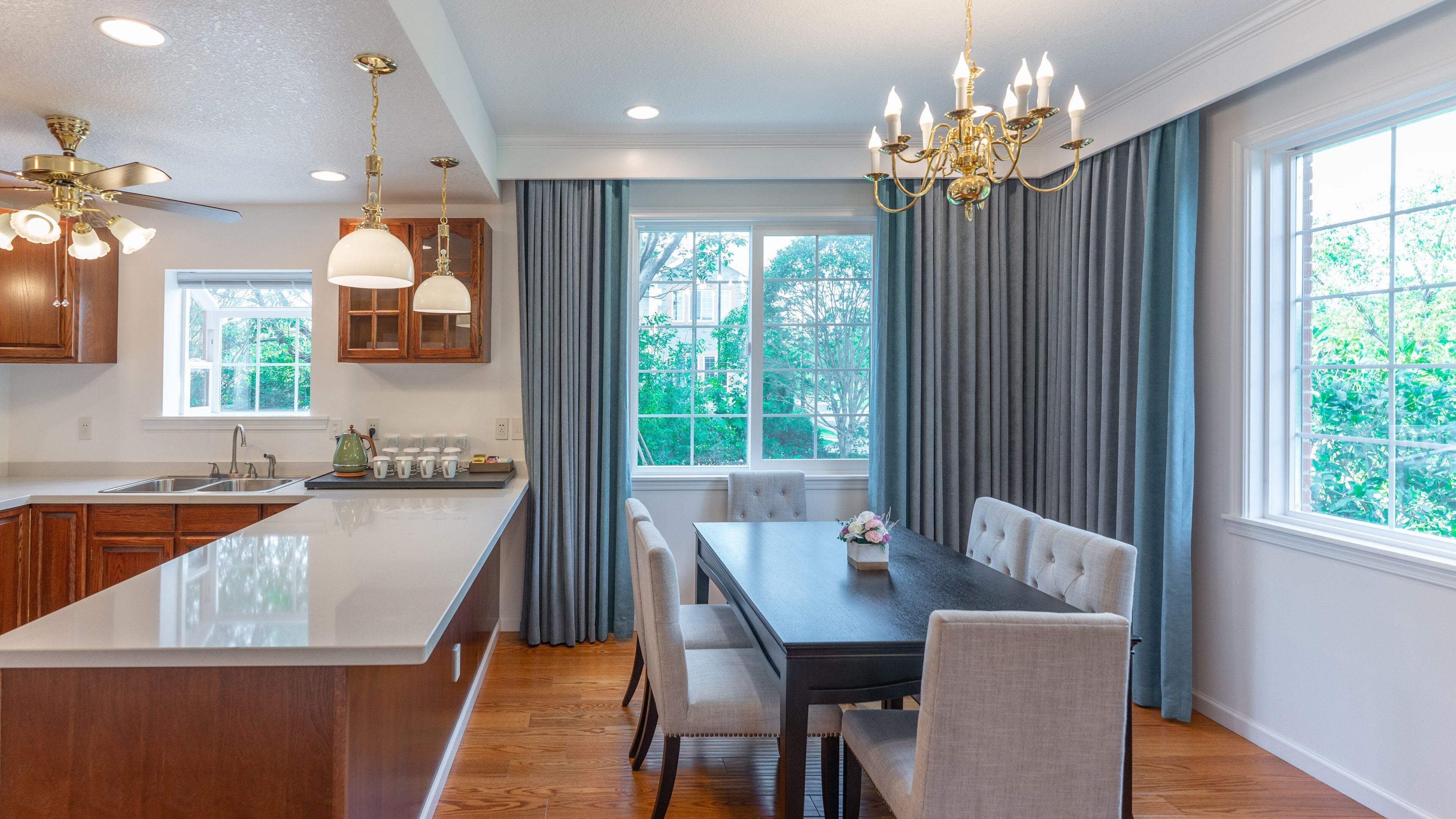 Una cocina moderna con una isla central, armarios de madera e iluminación colgante.