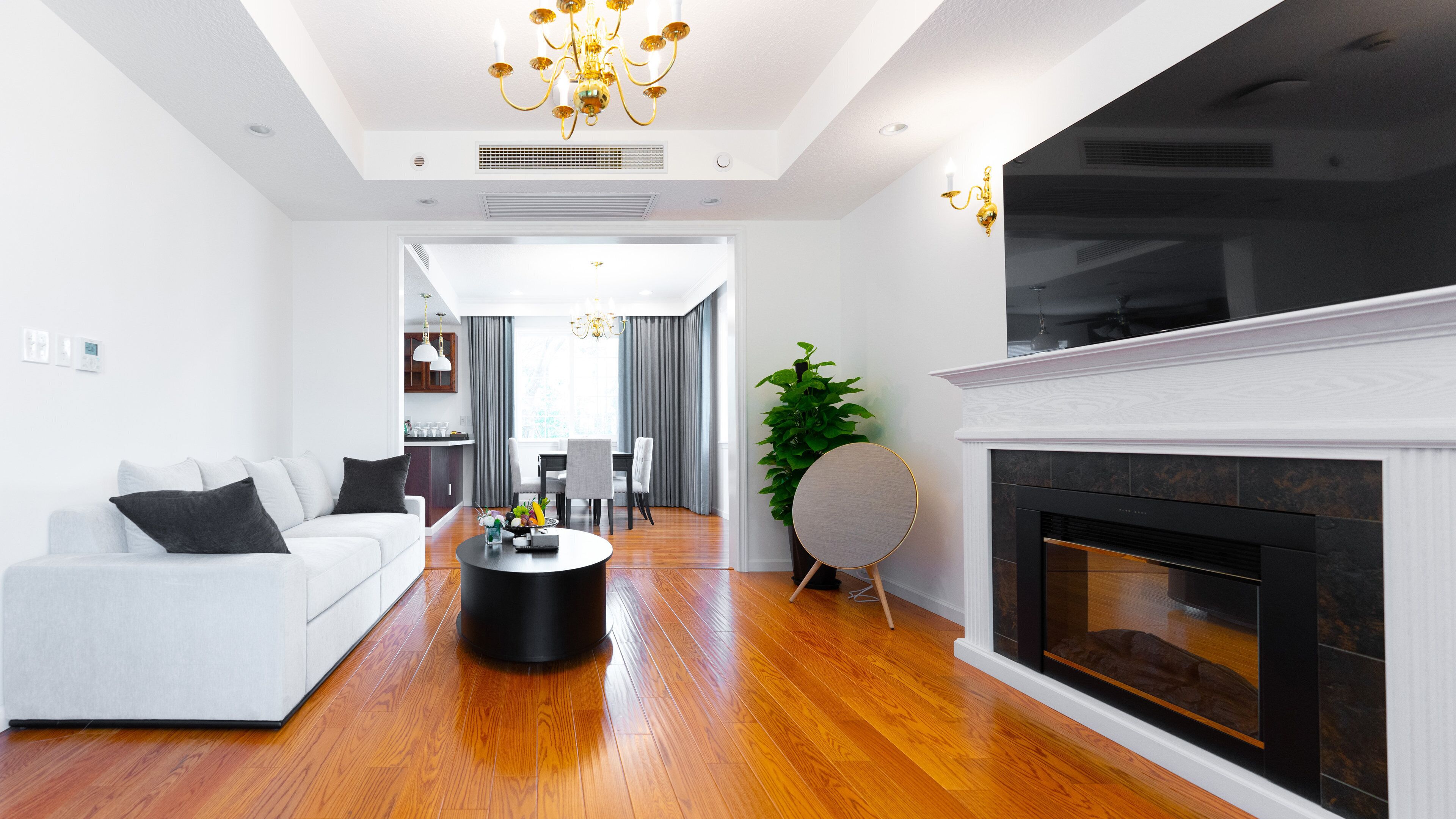 Ein modernes Wohnzimmer mit einem weißen Sofa, einem runden Couchtisch und einem Kamin.
