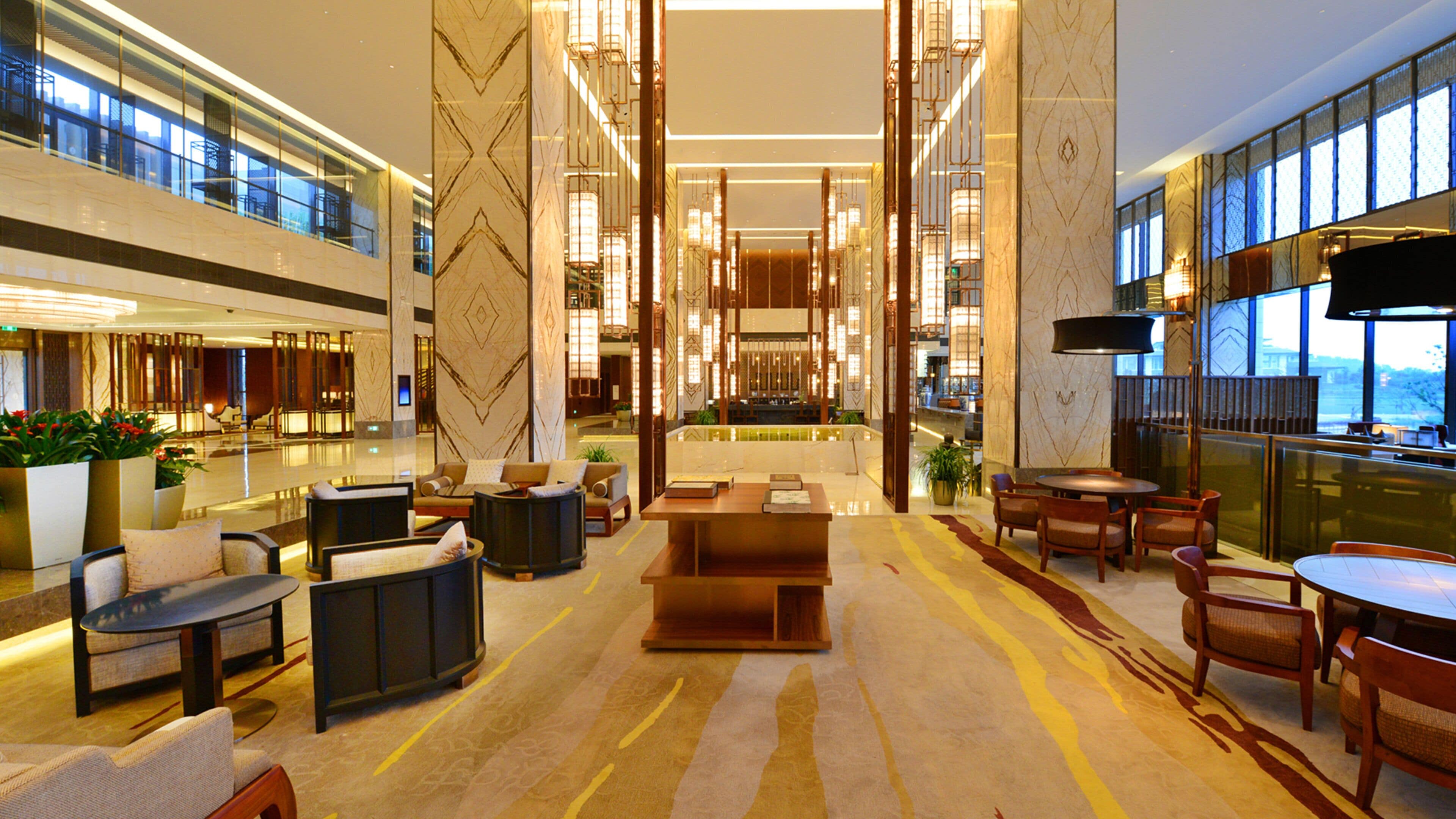 Eine geräumige Lobby mit einer zentralen Sitzecke, einer Bar und einem großen Fenster mit Blick.