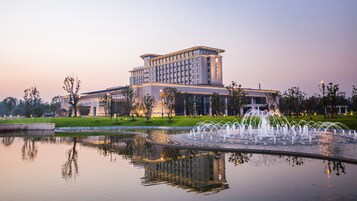 Un hotel moderno con un edificio grande y una fuente al frente.