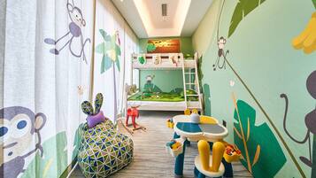 A child's bedroom with a bunk bed, a play area with toys, and a window with curtains.