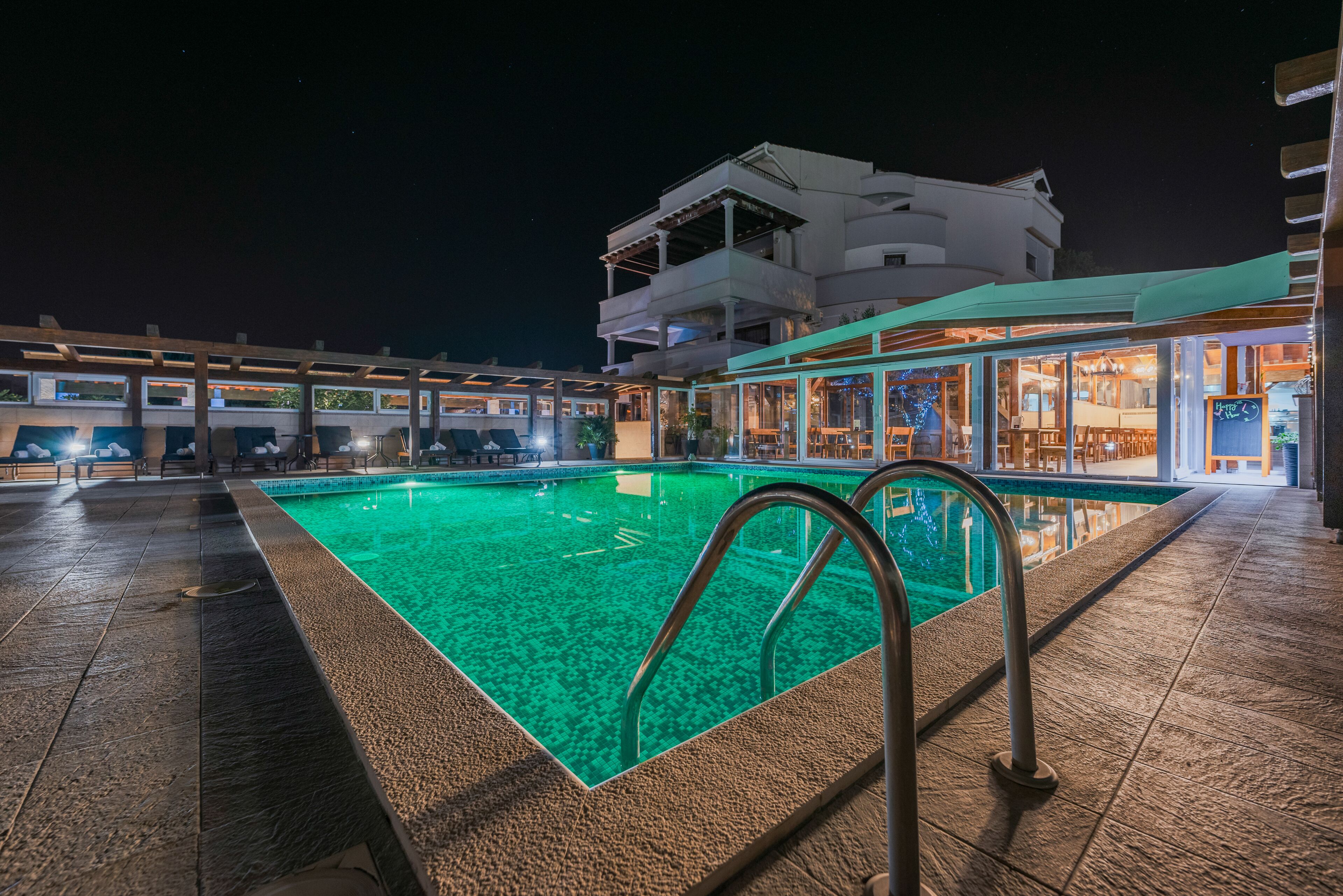 An outdoor swimming pool with a clear view of the adjacent building and lounge area.