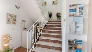 A staircase with white railings leading to a landing. - B&B Lucia (Olbia)