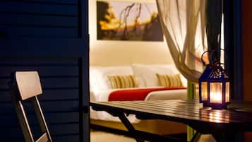 A cozy room with a bed, a table with a lantern, and a chair.