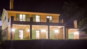 A two-story house with a stone facade, green shutters, and a balcony. - Vale de Ferreiros (Abrantes)