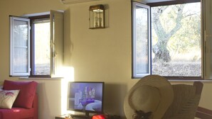 A living room with a television, a rocking chair, and a red sofa. - Vale de Ferreiros (Abrantes)