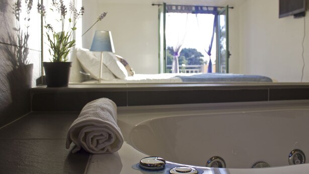A bathroom with a bathtub, a towel, and a potted plant. - Vale de Ferreiros (Abrantes)