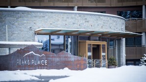 A building with a stone facade and a sign that reads "PEAKS PLACE." - Peaks Place (Laax)