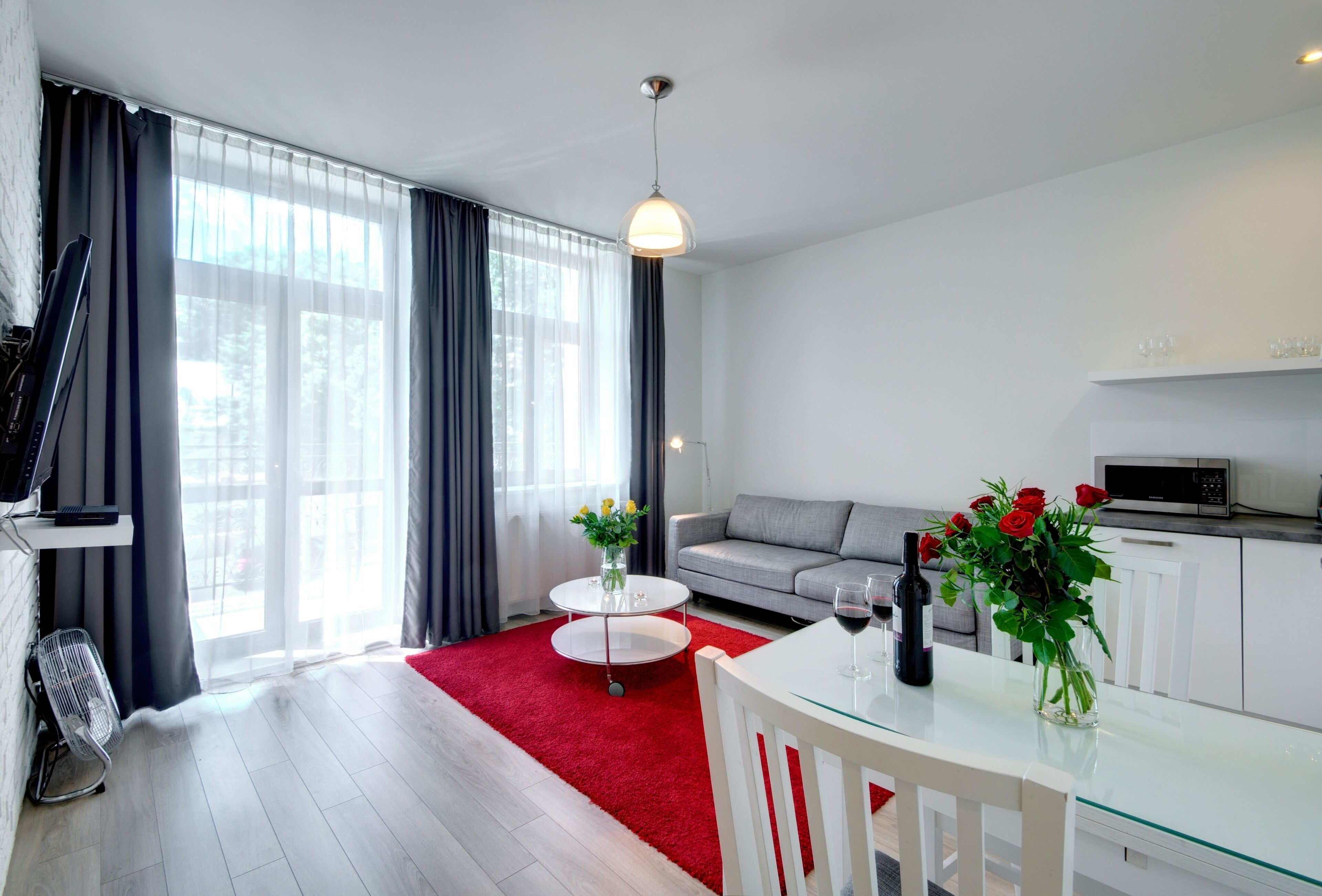 Una sala de estar moderna con un sofá, una mesa de comedor y una zona de cocina.