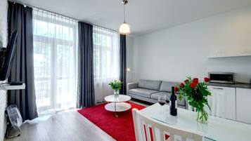 Una sala de estar moderna con un sofá, una mesa de comedor y una zona de cocina.