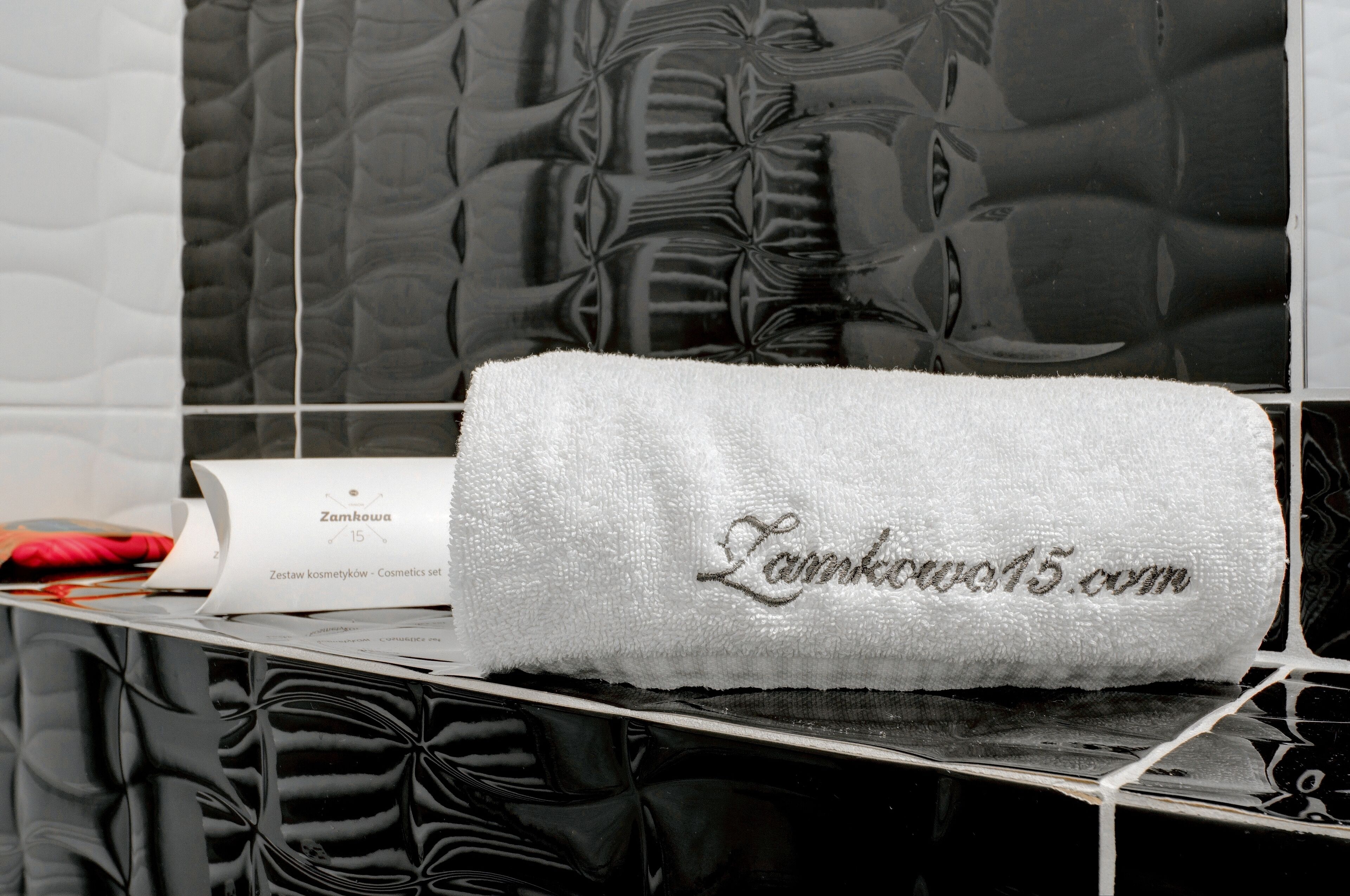 A white towel with embroidered text on a bathroom counter.