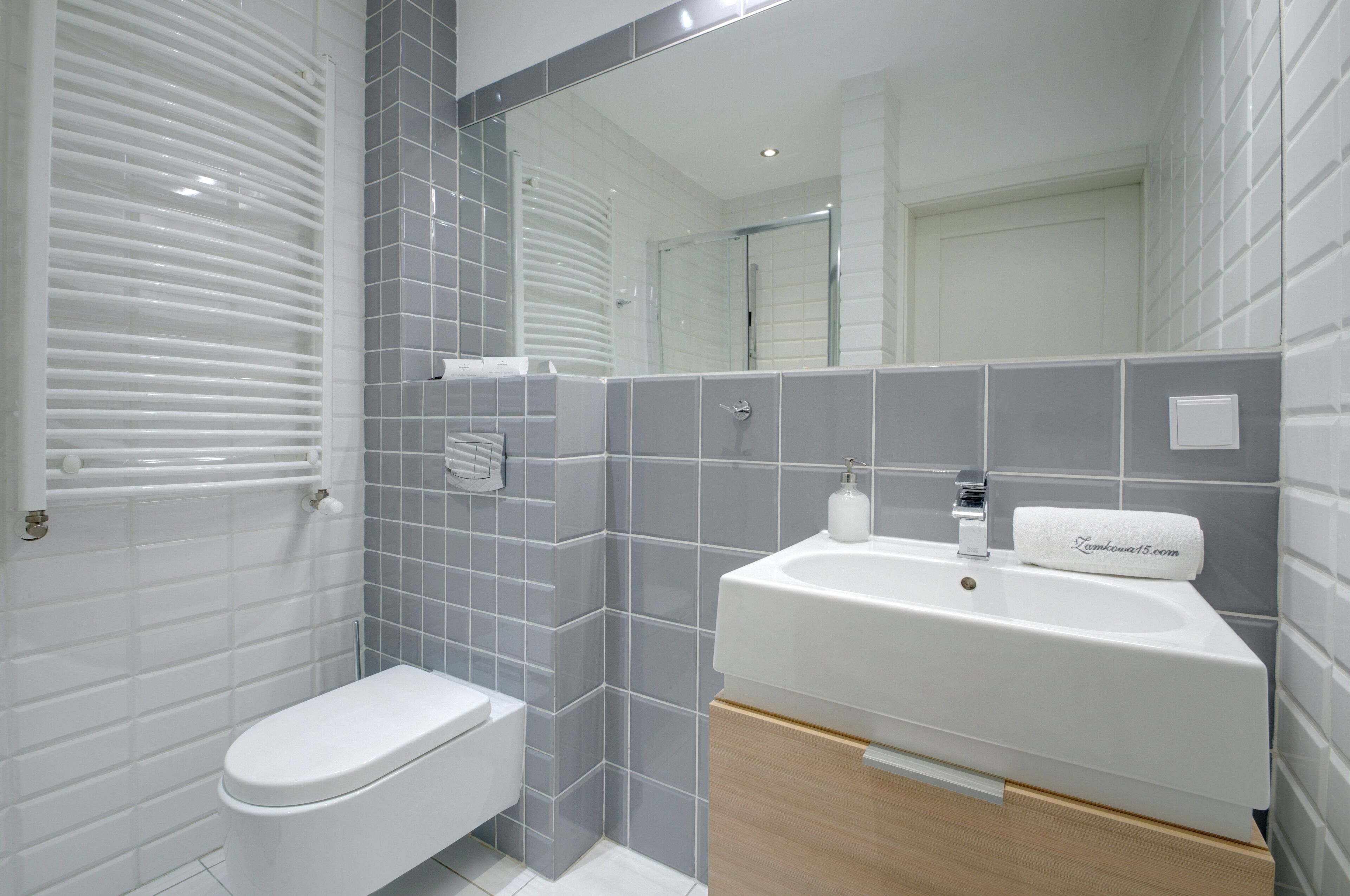 Un baño moderno con inodoro, lavabo y zona de ducha.