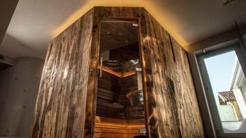 Una sauna con revestimiento de madera y puerta de vidrio, mostrando un letrero que indica una temperatura de 50°C.