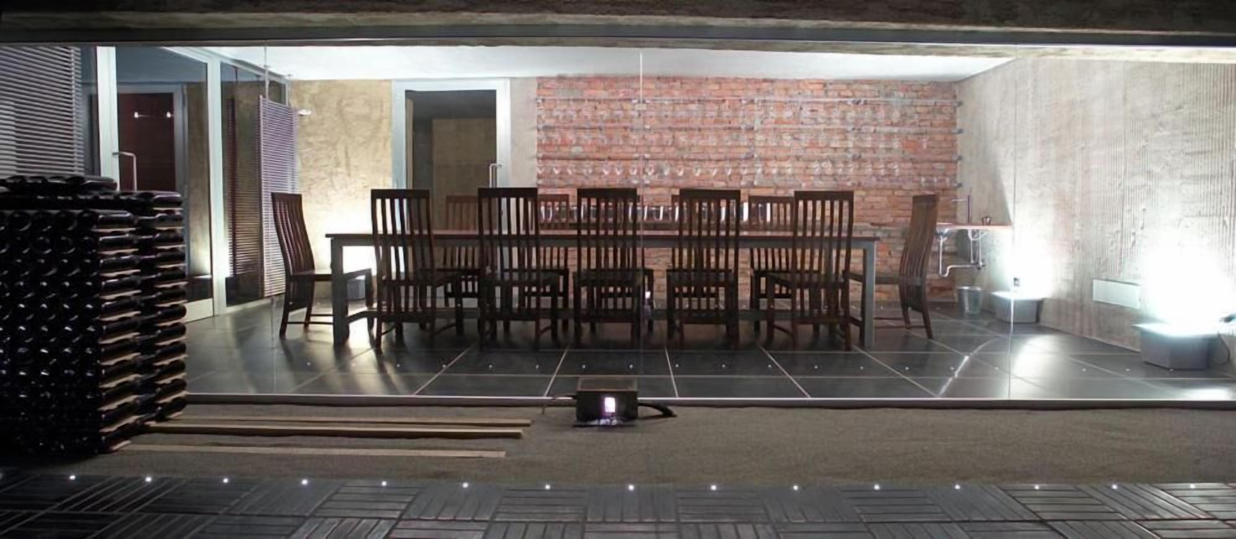 Ein Essbereich mit Backsteinwand, Fliesenboden und Tisch mit Stühlen.