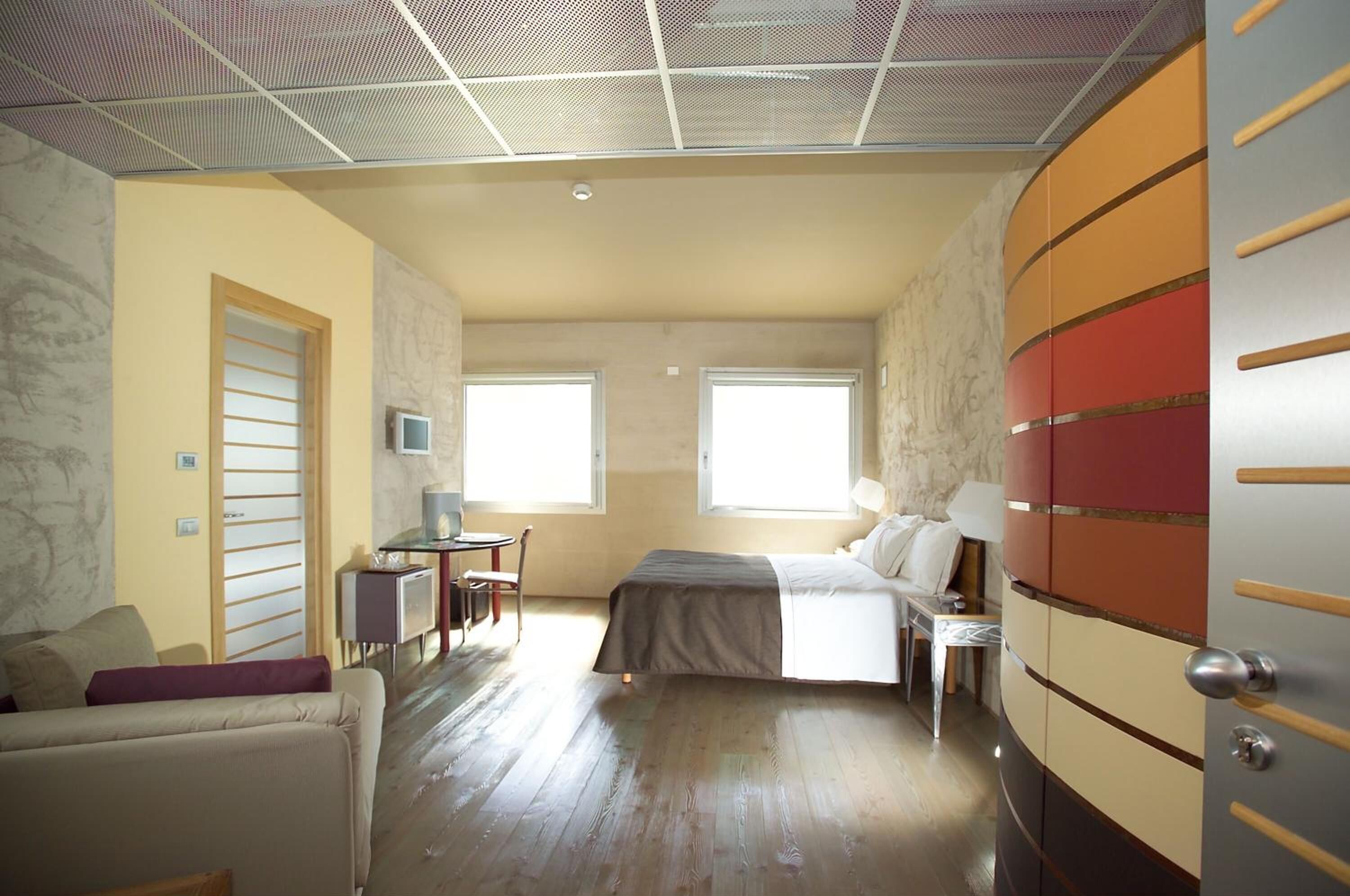 Une chambre à coucher avec un lit, un bureau, une chaise et un téléviseur.