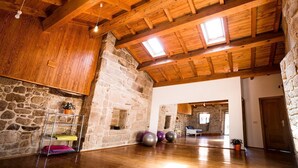 Una habitación amplia con techo de madera, paredes de piedra y techo inclinado.