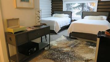 Un dormitorio con dos camas, un escritorio y una alfombra de diseño único.