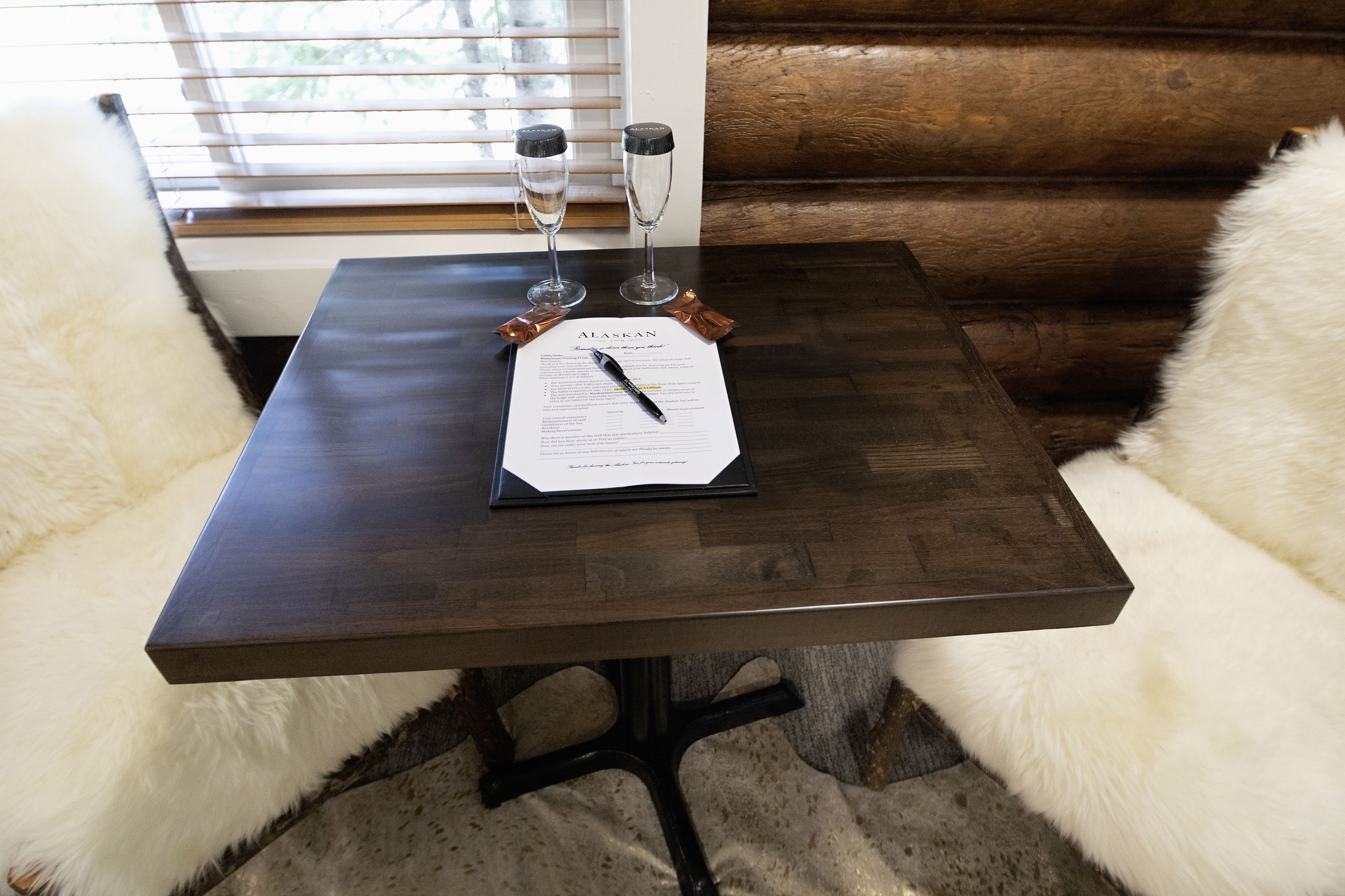 Una mesa de madera con un certificado y dos copas de champán.